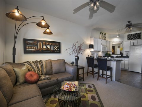 a living room and kitchen with a couch and a table