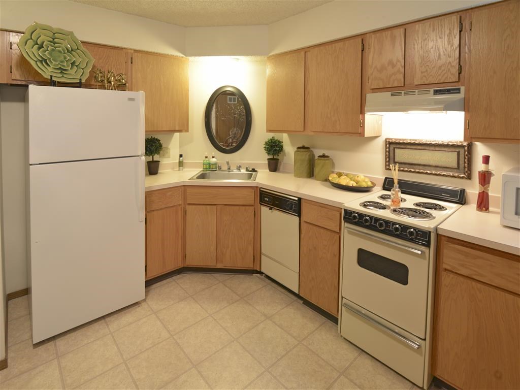 a kitchen with white appliances and wooden cabinets