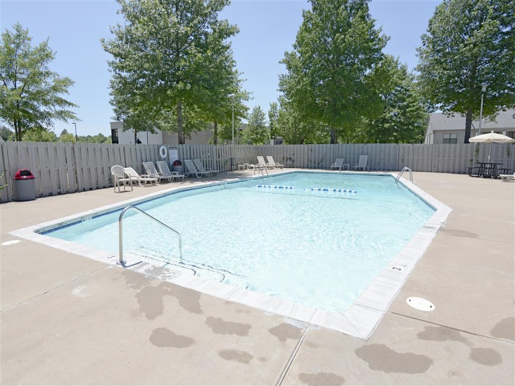 our apartments have a resort style pool with chairs and trees
