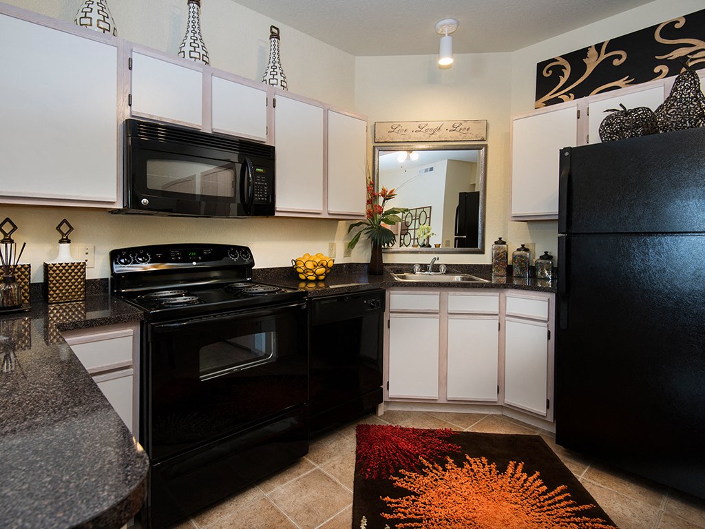 a kitchen with black appliances and white cabinets
