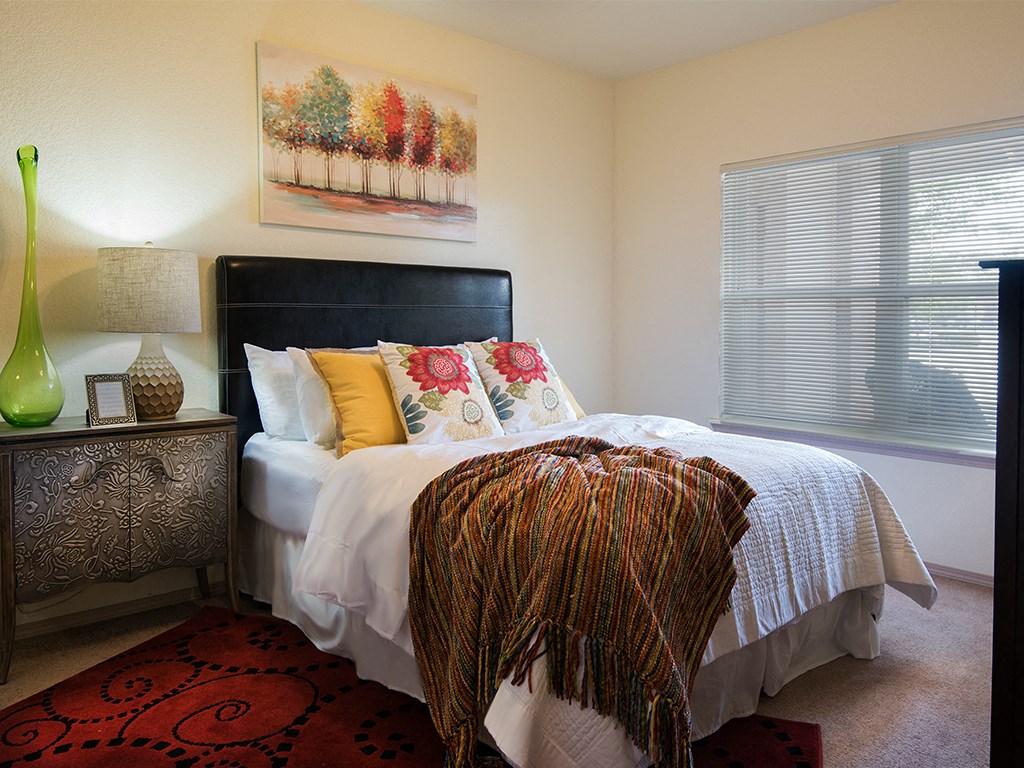 a bedroom with a bed and a large window