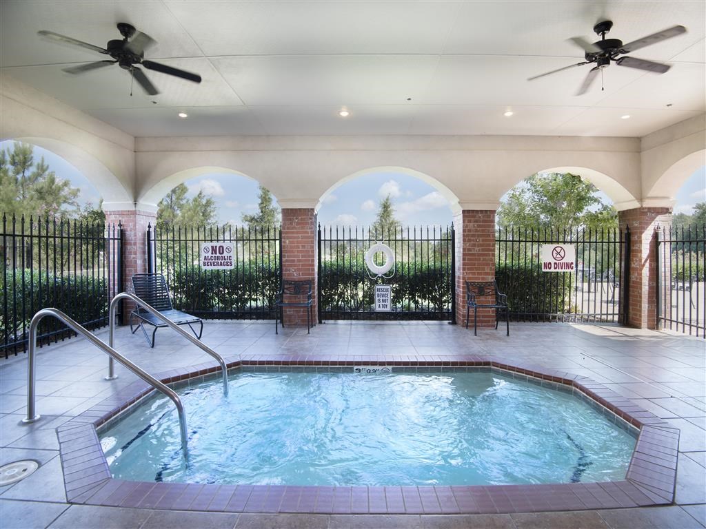 a resort style pool with a fence around it and two ceiling fans