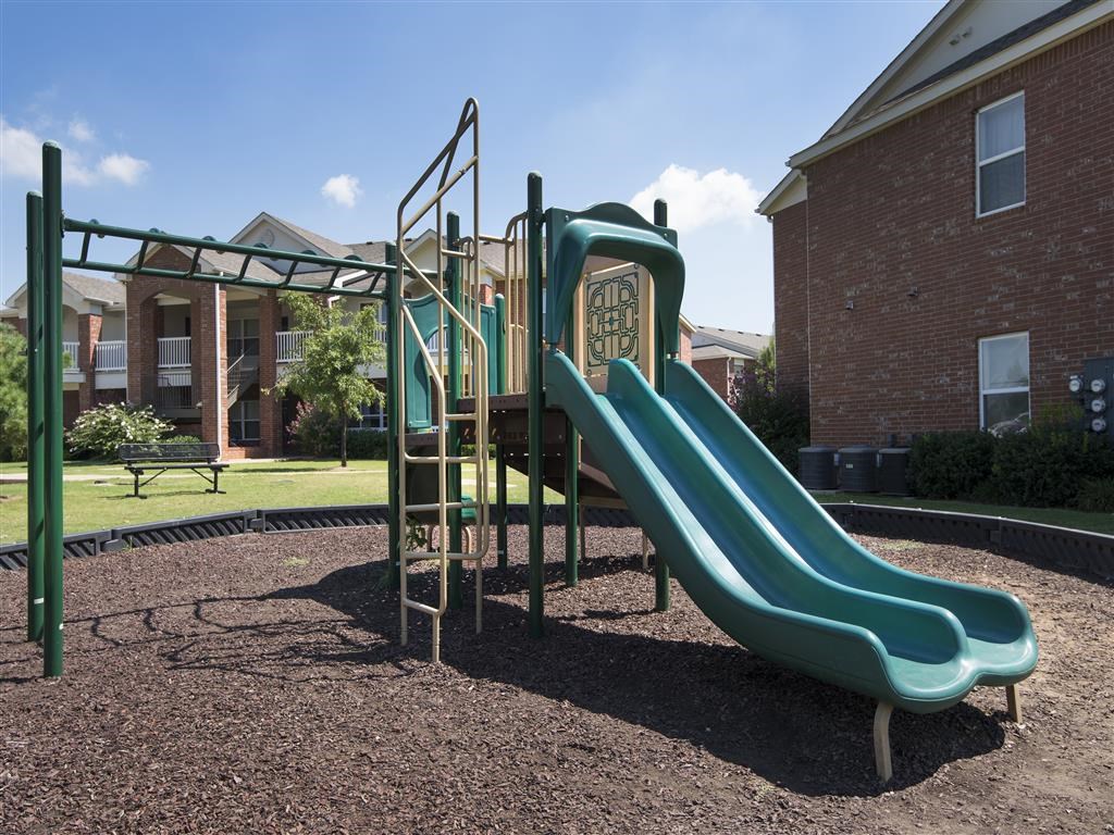 a playground with a slide in front of a building