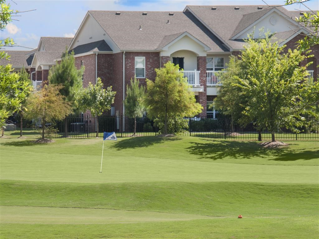 a golf course with a house in the background