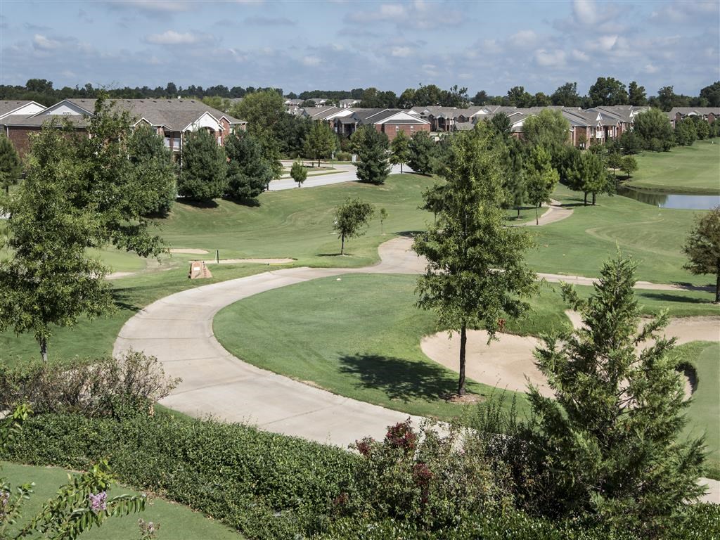 an aerial view of a golf course with houses in the background