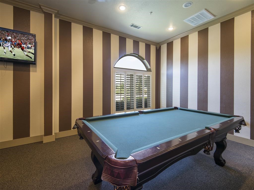a game room with a pool table and a tv