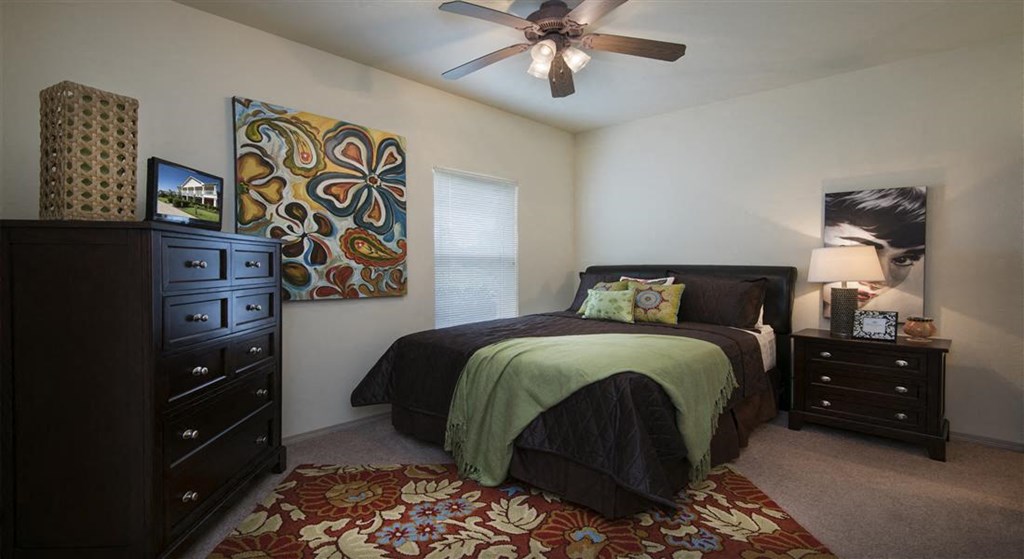 a bedroom with a bed and a ceiling fan