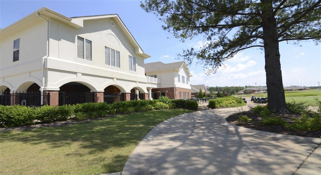 a large white building with a sidewalk in front of it