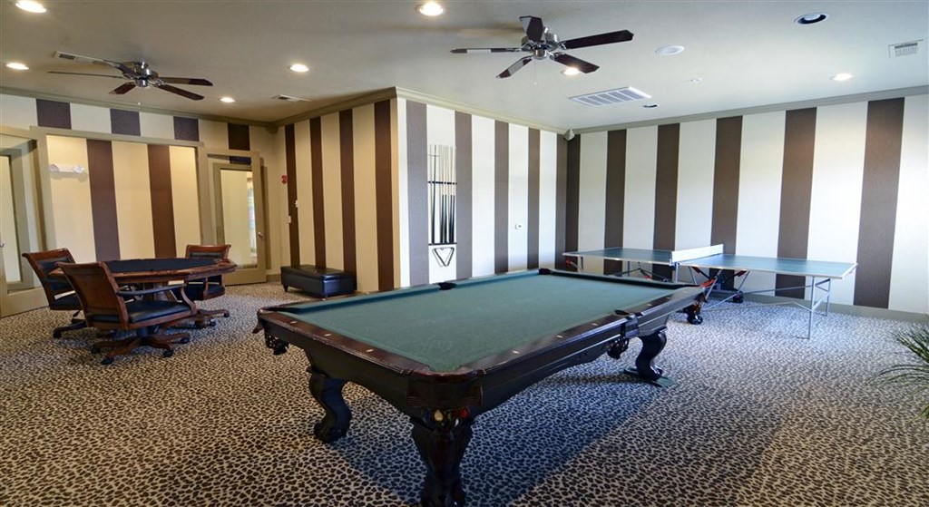 a game room with a pool table and chairs