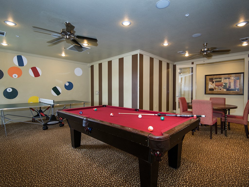 a game room with a pool table and a ceiling fan