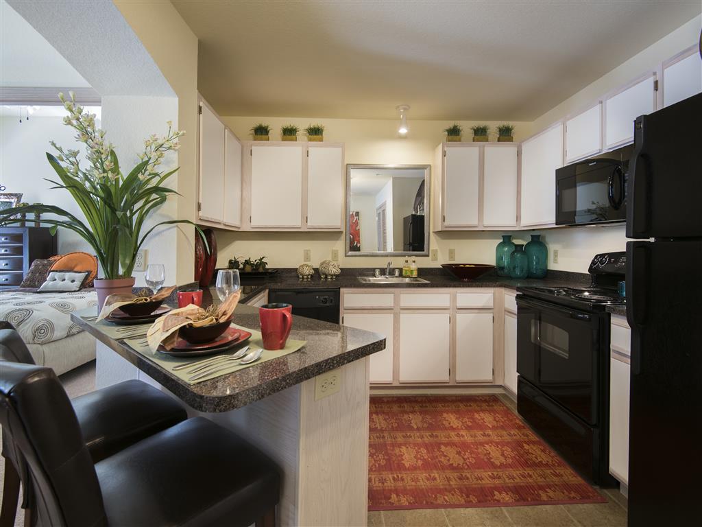 a kitchen with black appliances and white cabinets