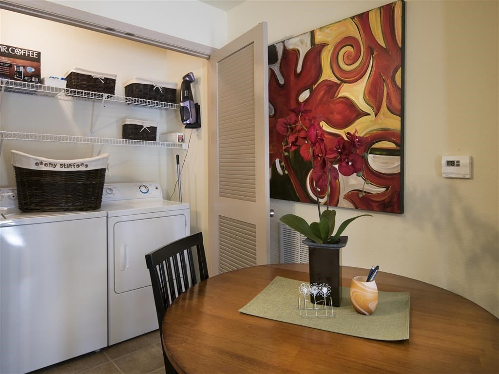 a kitchen with a table and a washing machine     and a painting