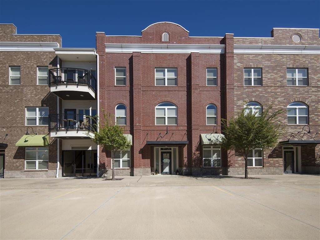 an empty parking lot in front of a brick building