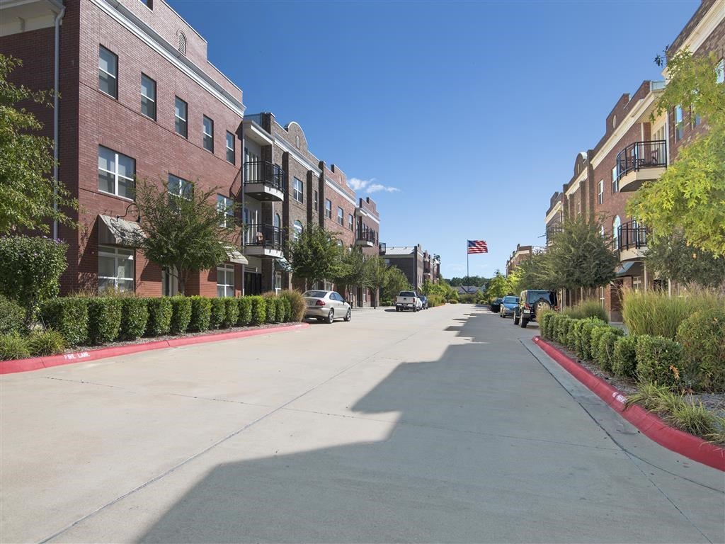 an empty street with buildings on both sides and an flag