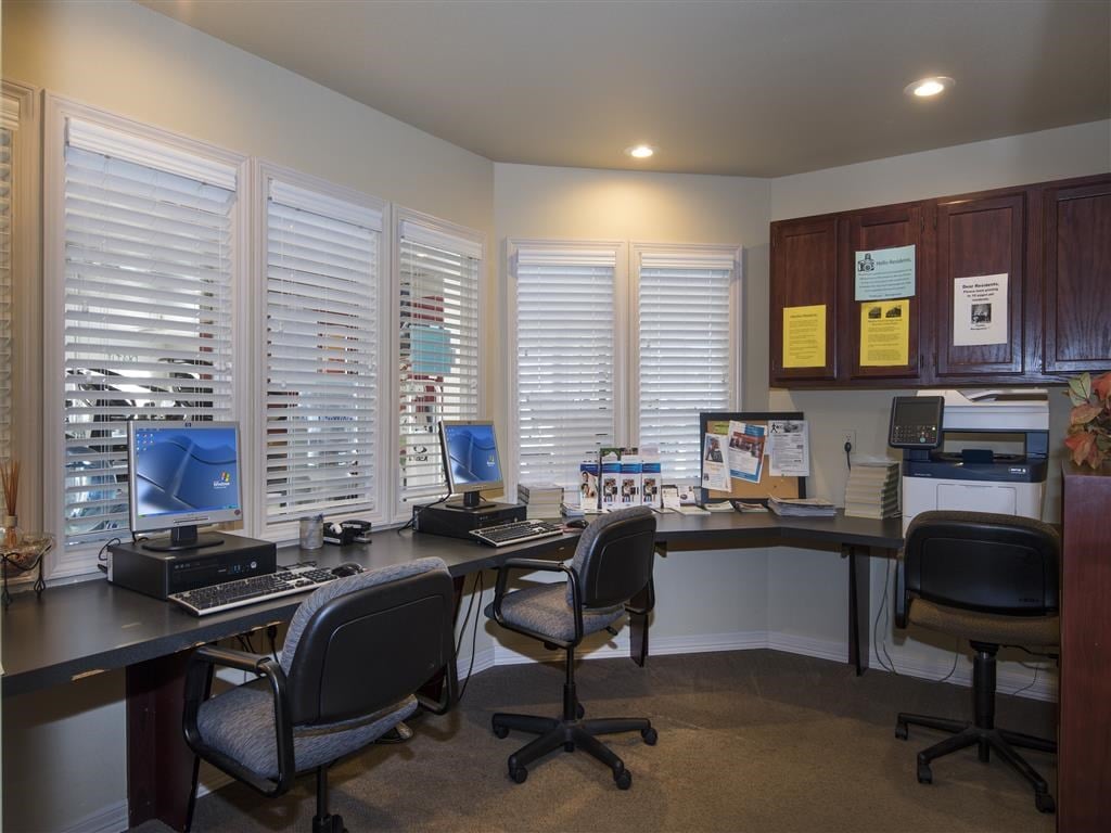 an office with two desks with computers and chairs