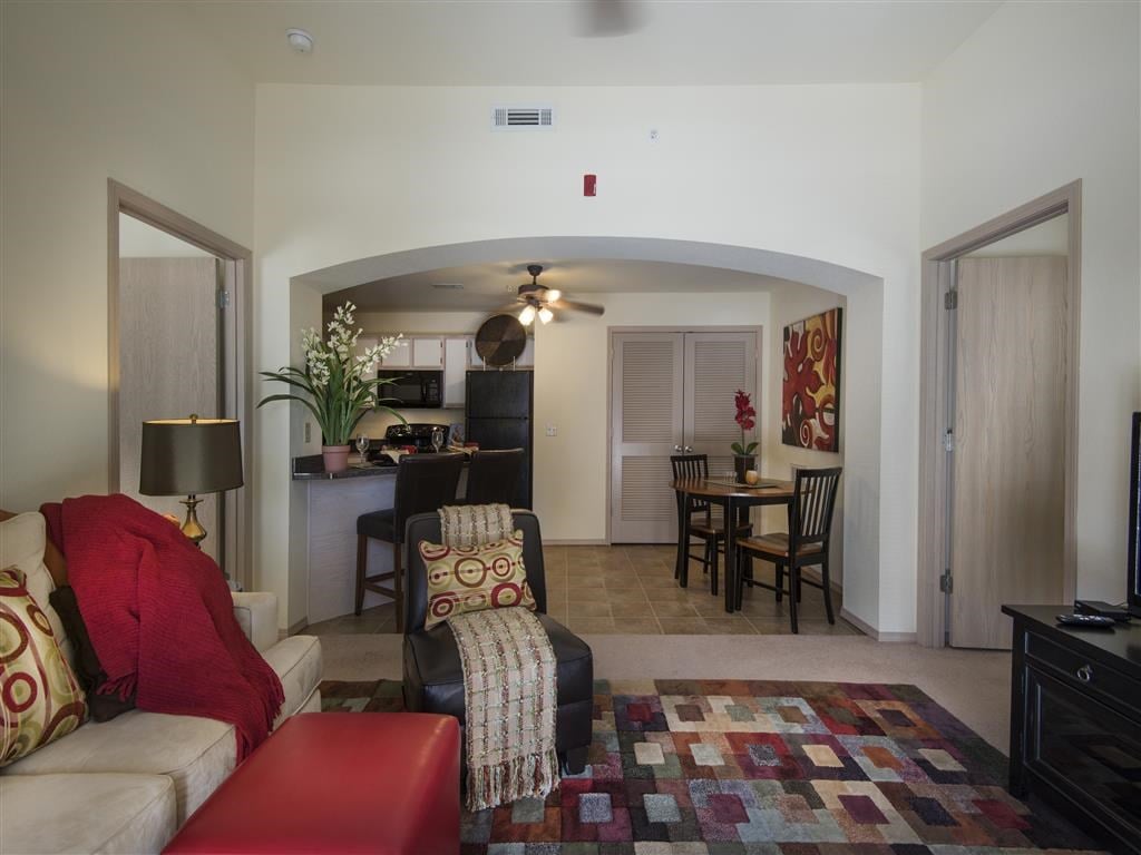 a living room with a couch and a chair and a kitchen