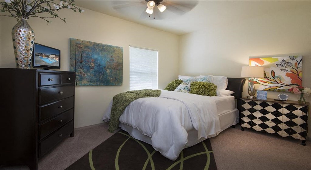 a bedroom with a bed and a ceiling fan
