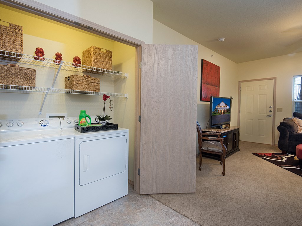 a laundry room and living room with a white washer and dryer in it
