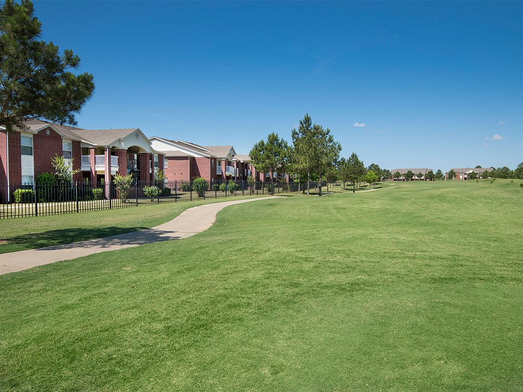 a large green lawn in front of a row of houses