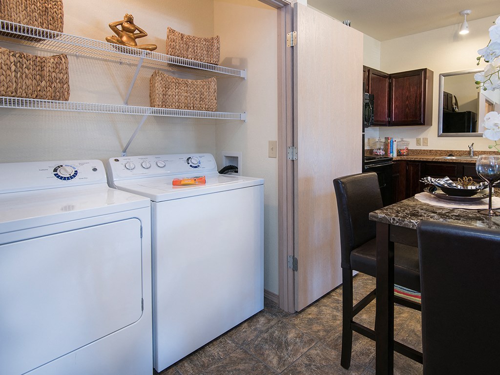 a kitchen with a washer and dryer in it and a table with chairs