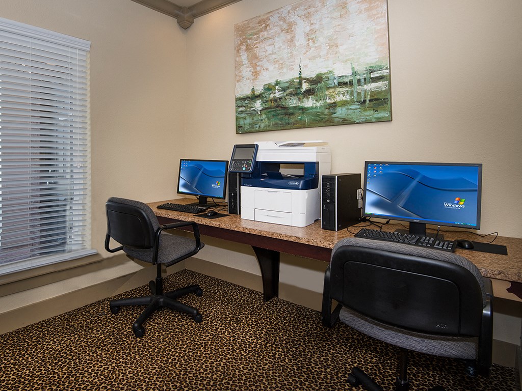 an office with two computers and a printer on a desk