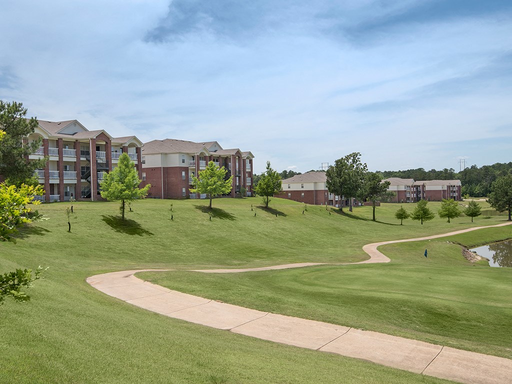 a golf course with an apartment building in the background