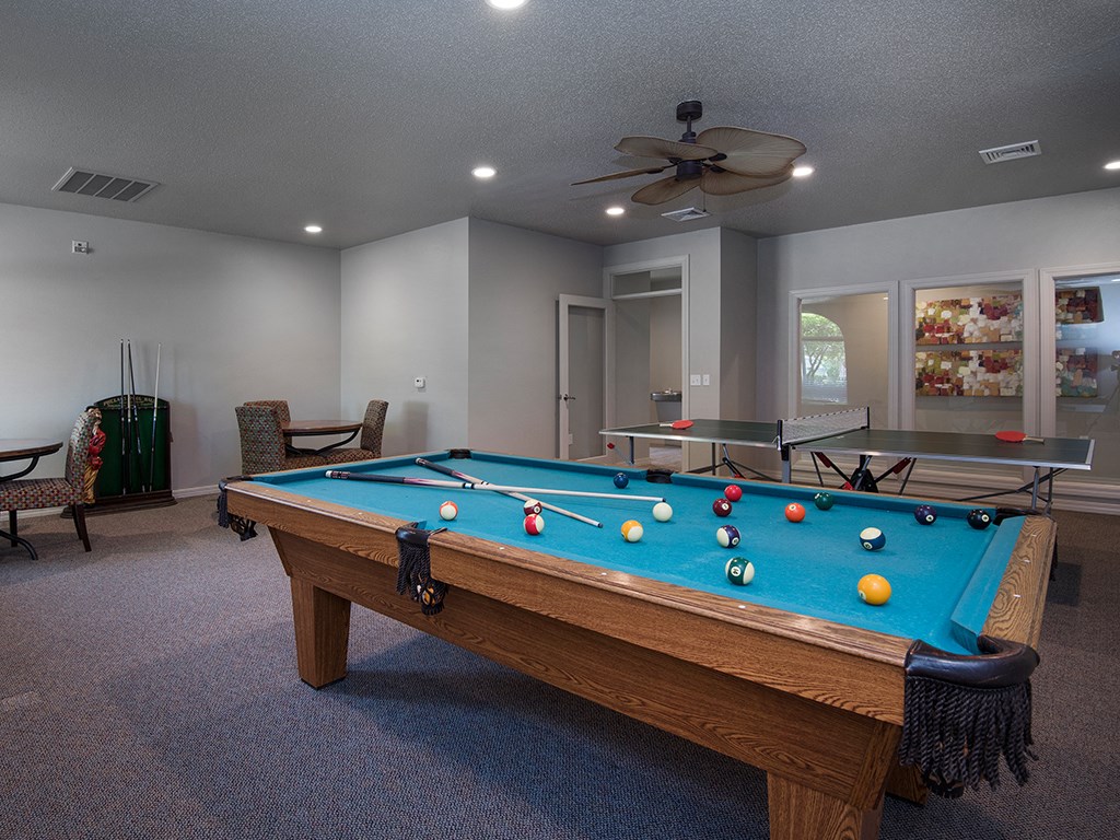 a pool table in the clubhouse of a home with a game room