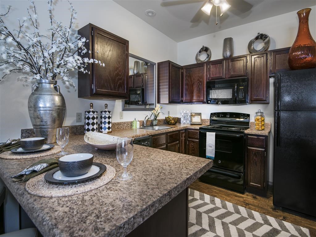 a kitchen with granite counter tops and black appliances
