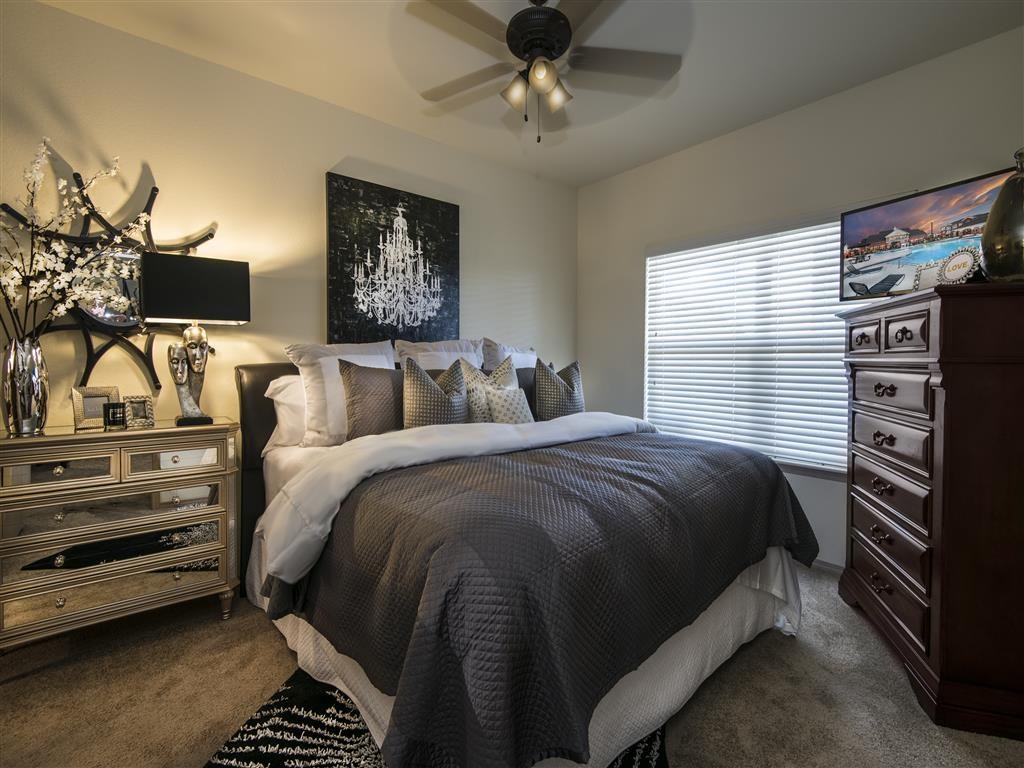 a bedroom with a bed and a ceiling fan