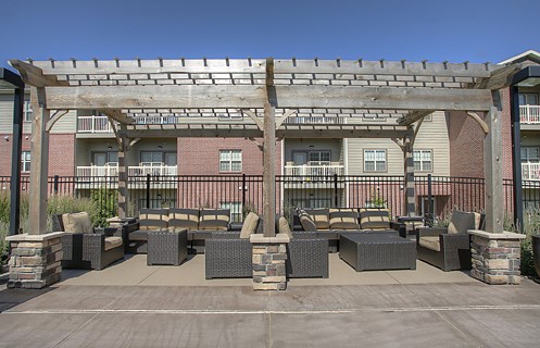 an outdoor patio area with tables and chairs in front of a building