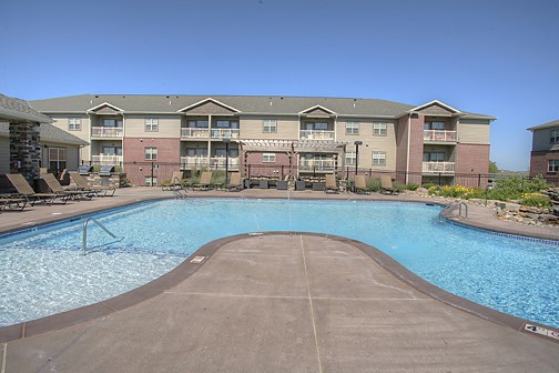 a swimming pool with an apartment building in the background