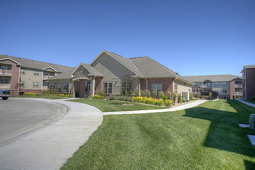 a row of houses in a neighborhood with a sidewalk and green grass