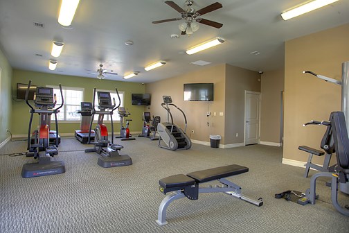 a gym with exercise equipment and a tv