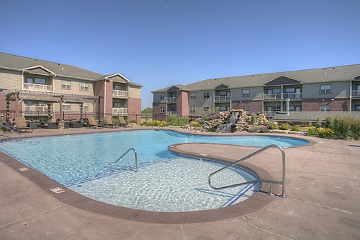 a swimming pool with an apartment building in the background