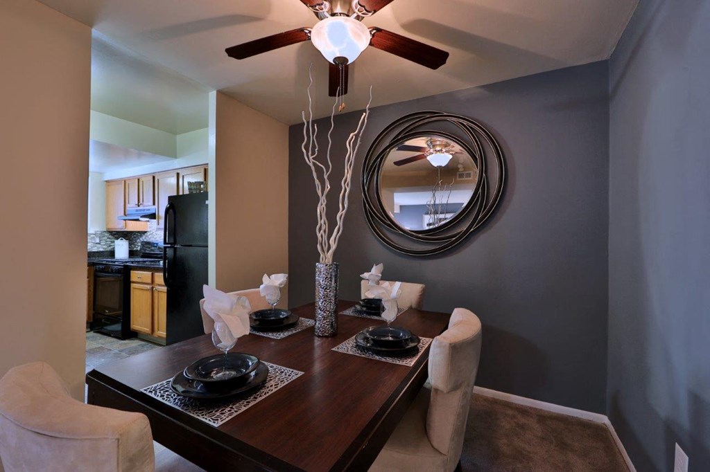 a dining room with a table and chairs and a ceiling fan
