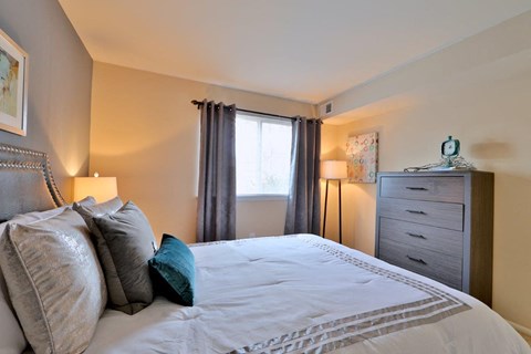 a bedroom with a bed and a dresser and a window