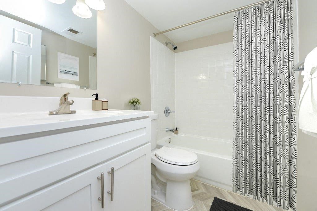 a white bathroom with a shower and a toilet