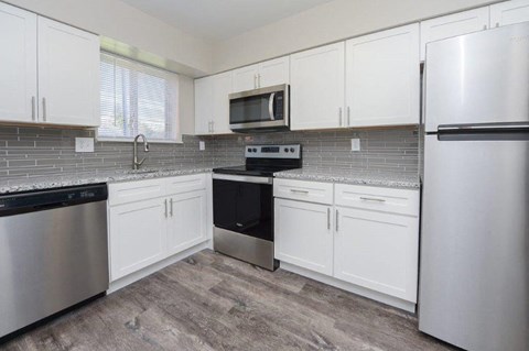 a kitchen with stainless steel appliances and white cabinets