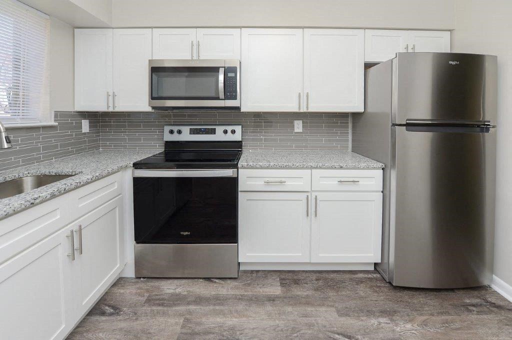 a kitchen with stainless steel appliances and white cabinets
