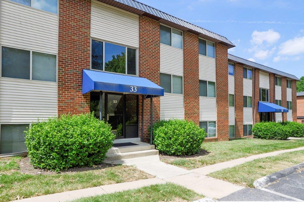 the front of a brick building with a blue awning