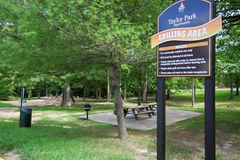 a sign for the grilling area in a park