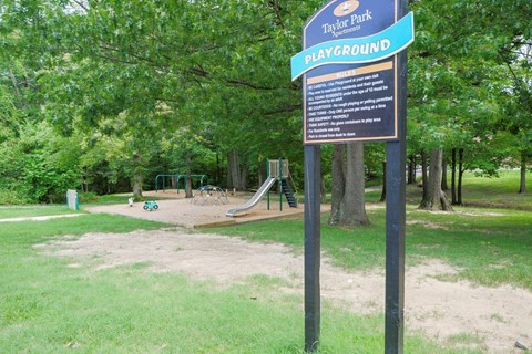 a sign for a playground in a park