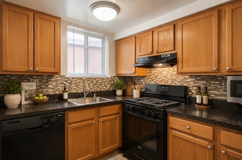 A kitchen with black appliances and wooden cabinets.