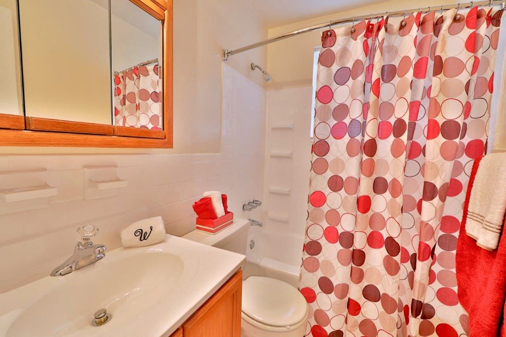 a bathroom with a shower curtain and a sink and a toilet