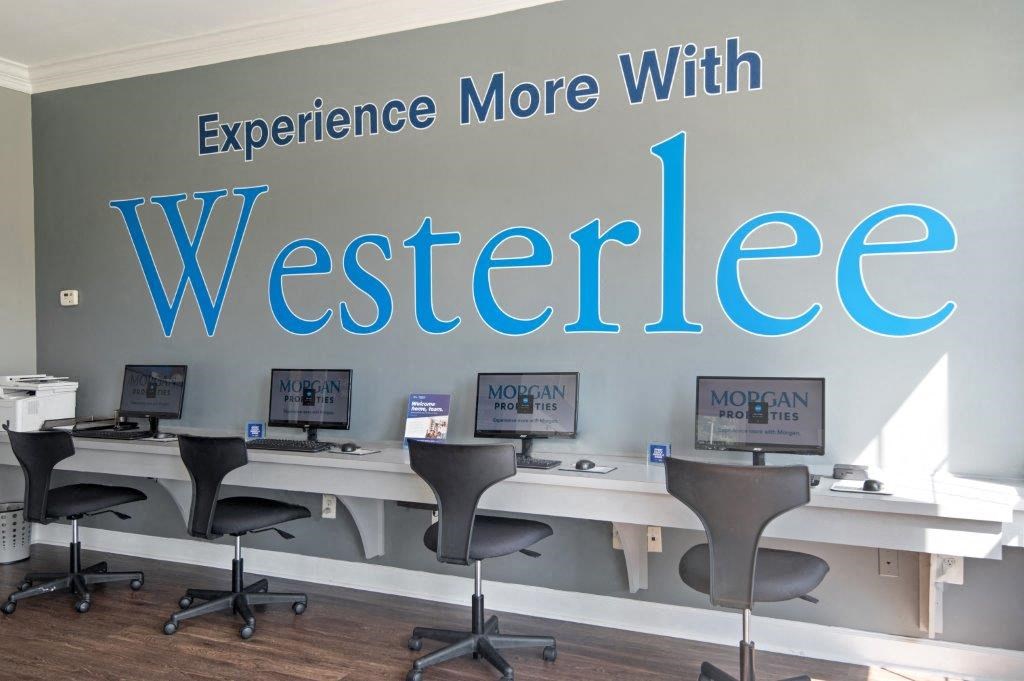 a wall with the words experience more with website and desks with computers