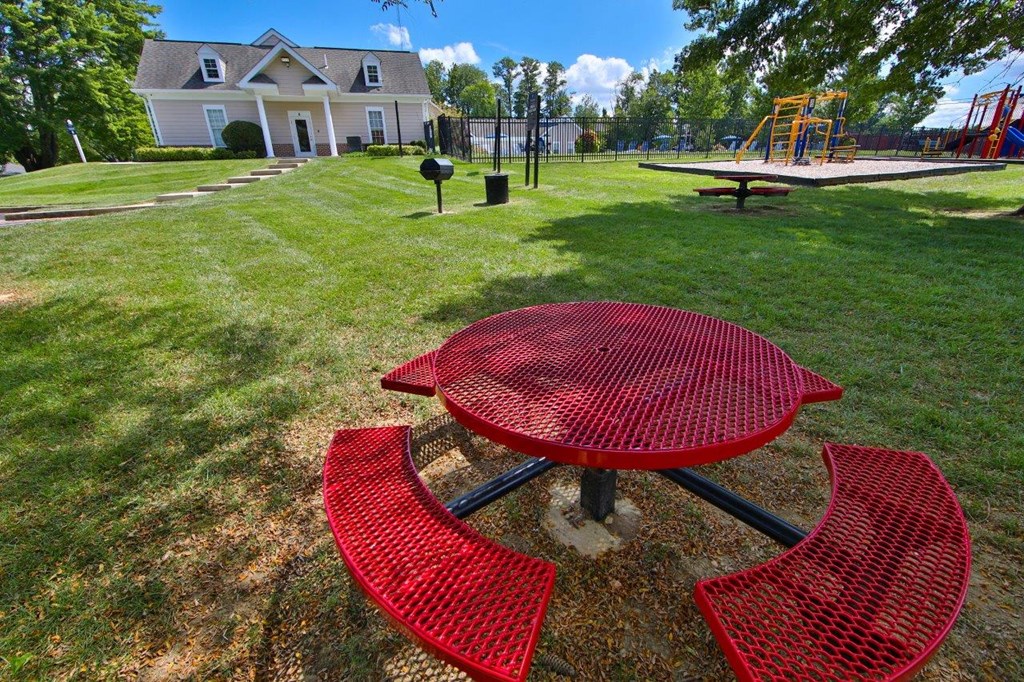 a backyard with a red picnic table and a playground