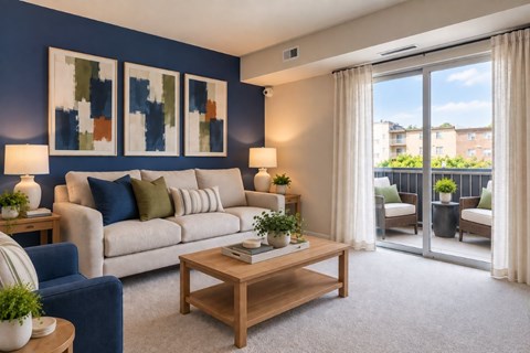 A living room with a blue couch, a wooden coffee table, and a painting on the wall.