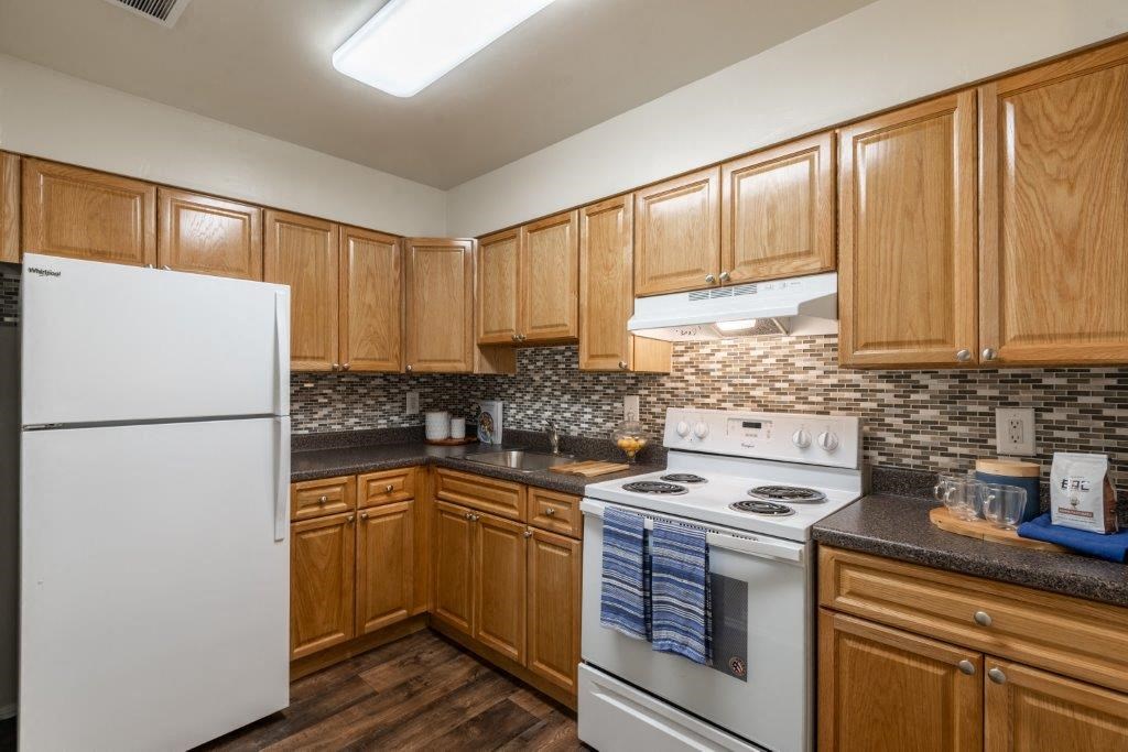 a kitchen with white appliances and wooden cabinets