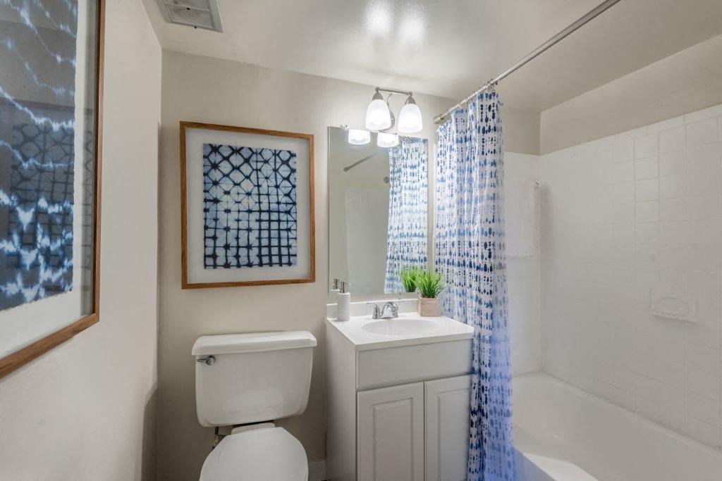a white bathroom with a white toilet and a sink