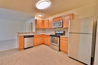 a kitchen with stainless steel appliances and wooden cabinets